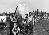 Link to Enlarged Photo of Former POWs Standing By Abandoned Axis Aircraft