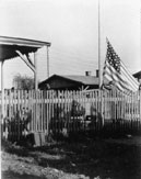 Link to Enlarged Photo of Old Glory Rising Above Camp
